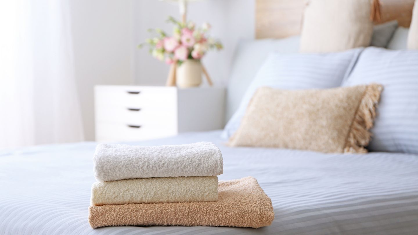 Clean and organized bedroom with neatly folded towels